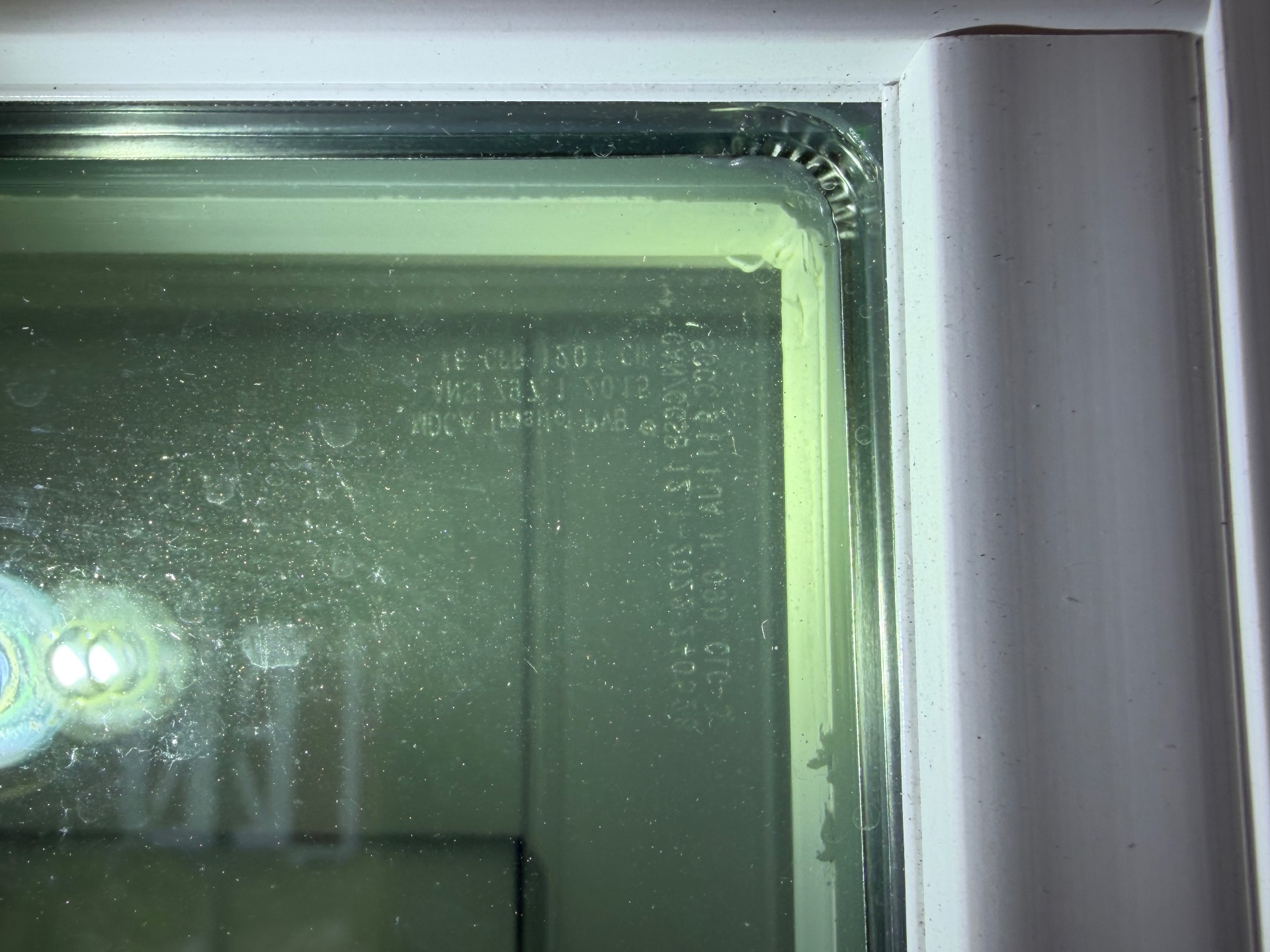 Impact-rated window manufacturer stamp verifying opening protection