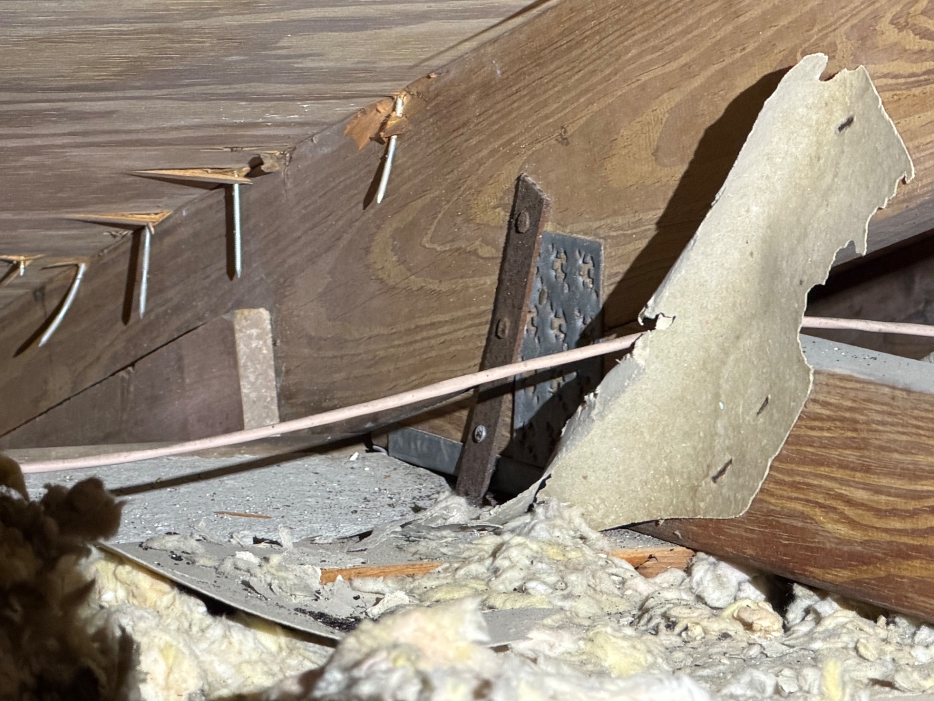 Attic framing showing roof-to-wall connection during inspection