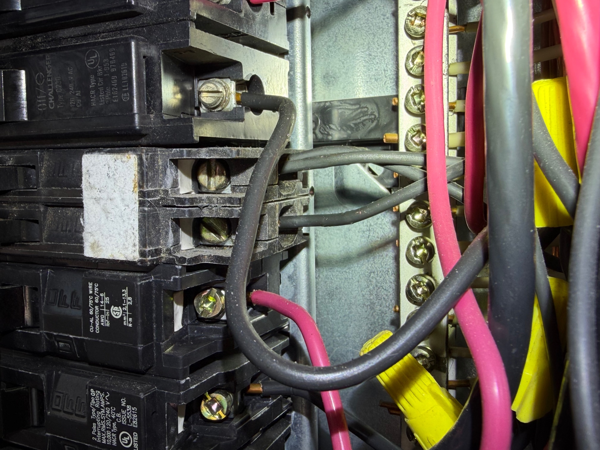Double-tapped breaker in a Challenger panel — two conductors landed under a single breaker lug