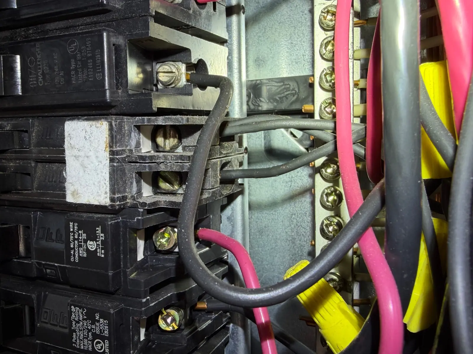 Double-tapped breaker in a Challenger panel — two conductors landed under a single breaker lug