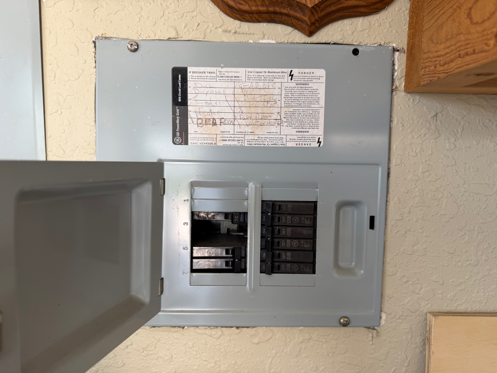 Panel interior with empty breaker slots and missing filler plates exposing the bus bar