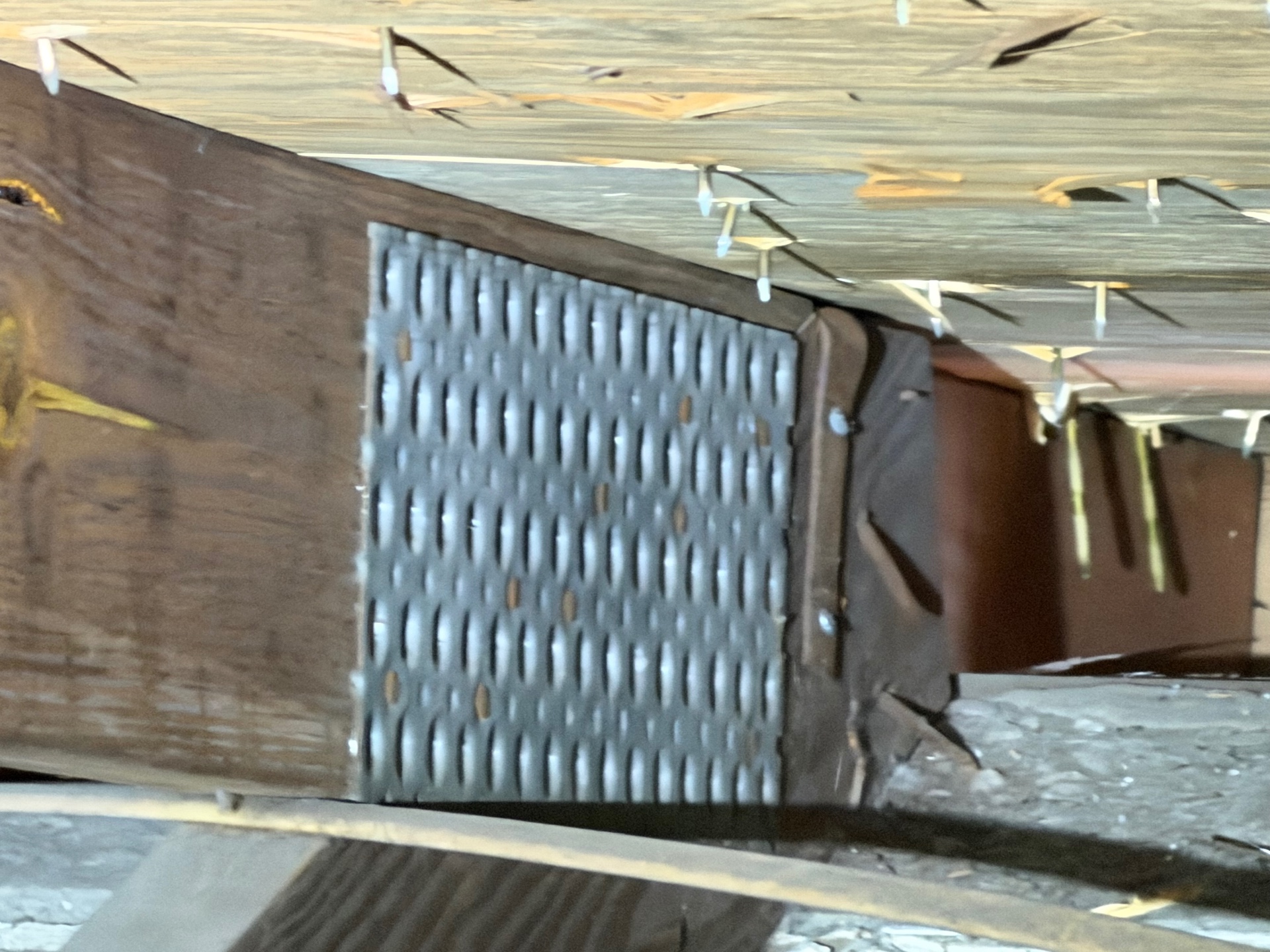 Close-up of a hurricane strap with multiple nails connecting roof truss to wall plate